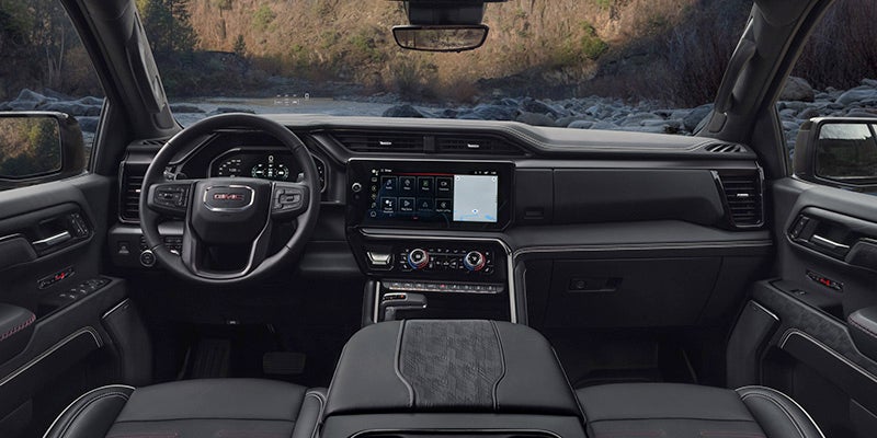 Interior view of the 2024 GMC Sierra 1500 from the backseat view showing the dashboard and steering wheel