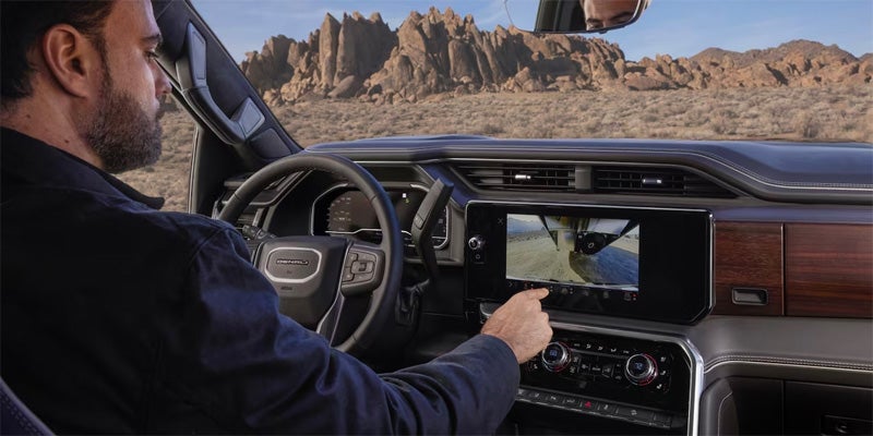 Man using the infotainment system in a 2024 GMC Sierra 2500HD