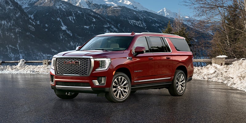 Image of a red 2024 GMC Yukon XL with snowy mountains in the background
