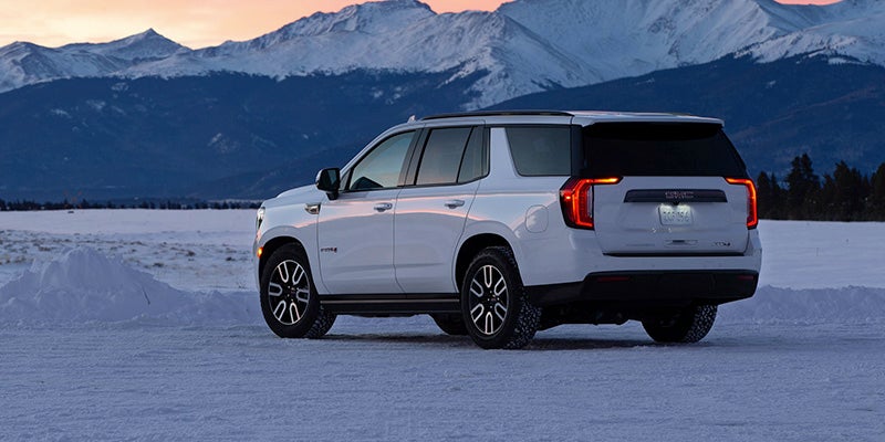 2024 Yukon on a snowy surface with snowy mountain in the background