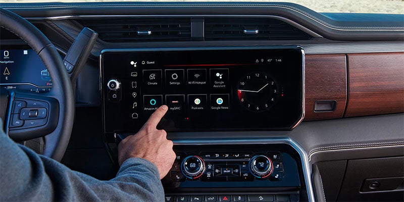 Interior image of a 2025 GMC Sierra 3500HD of a person using the infotainment system